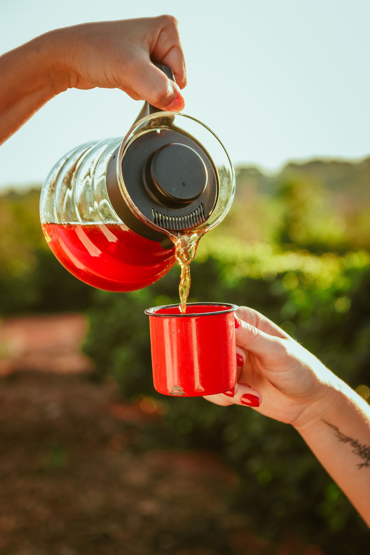 Café sendo servido em xícara esmaltada vermelha